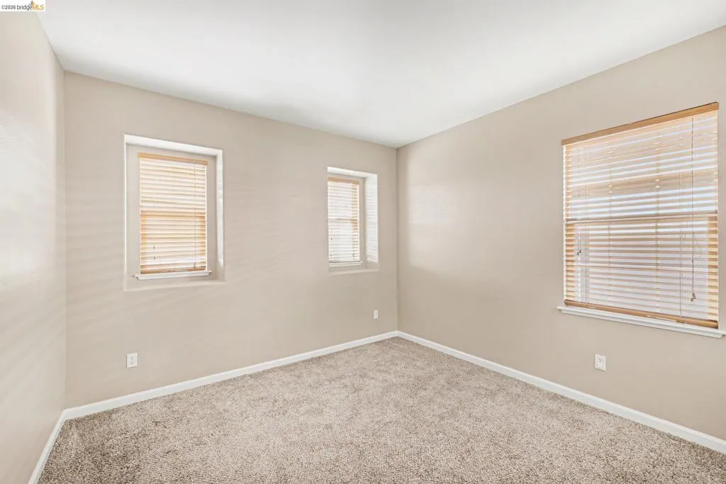 Carpeted empty room with baseboards