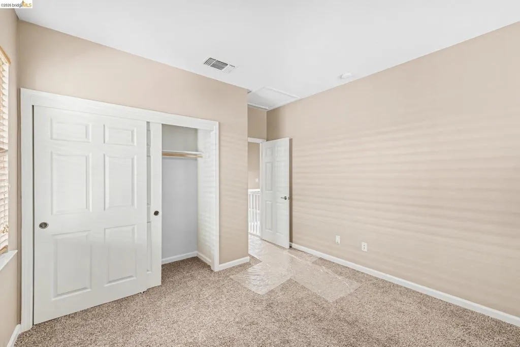 Unfurnished bedroom with a closet and light carpet