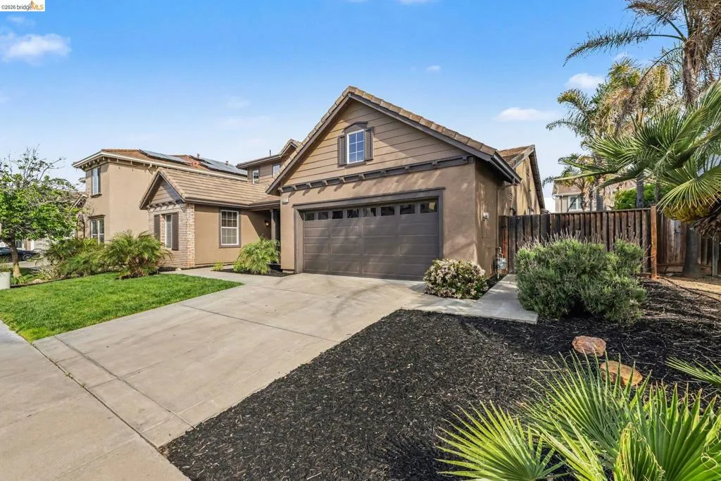 Traditional-style home featuring driveway, stucco siding, and a garage