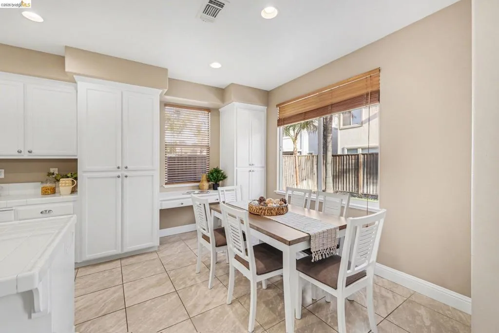 Dining area with light tile patterned floors and recessed lighting