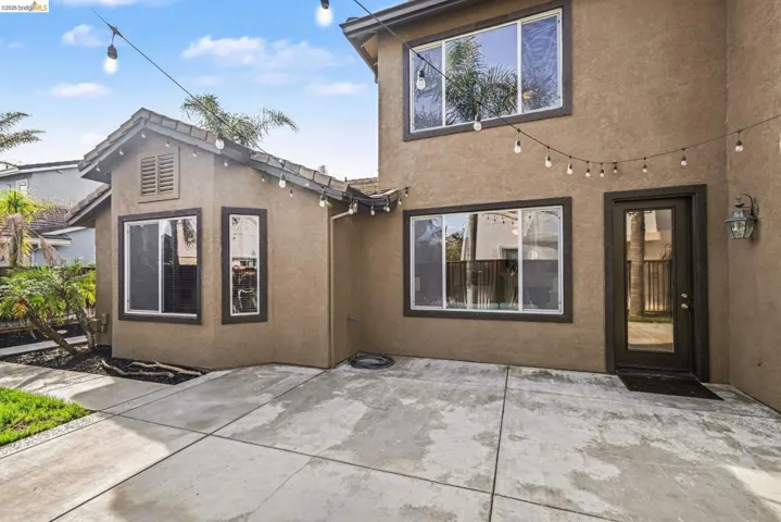 Back of house with stucco siding and a patio area