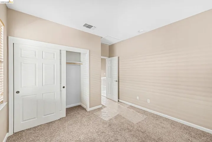 Unfurnished bedroom with a closet and light carpet