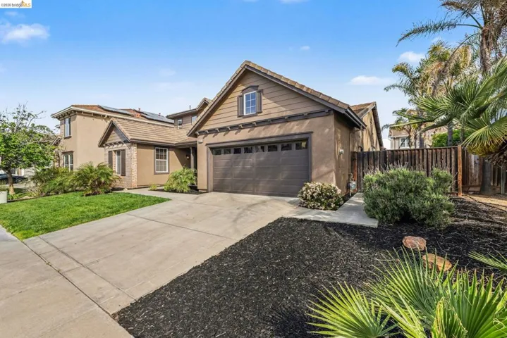 Traditional-style home featuring driveway, stucco siding, and a garage