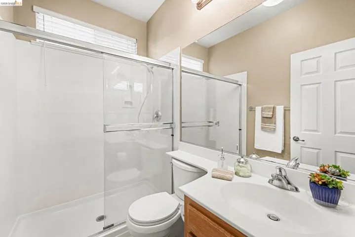 Full bathroom with vanity and a shower stall