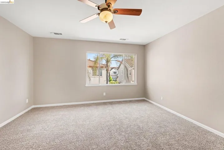 Empty room featuring carpet and ceiling fan