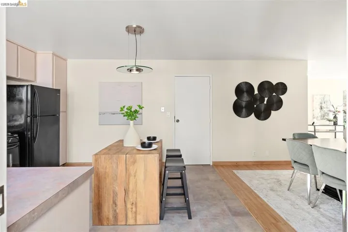 Kitchen with black appliances, pendant lighting, light countertops, and light wood-style floors