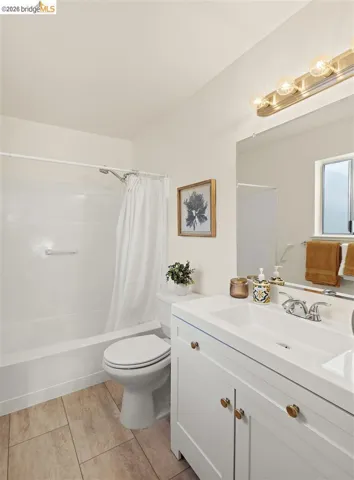 Bathroom featuring vanity and shower / bath combination with curtain