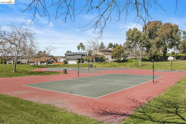 View of tennis court with a yard, community basketball court, and a residential view
