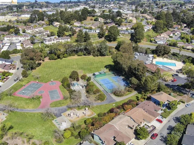 Aerial view of property's location featuring nearby suburban area and a pool area