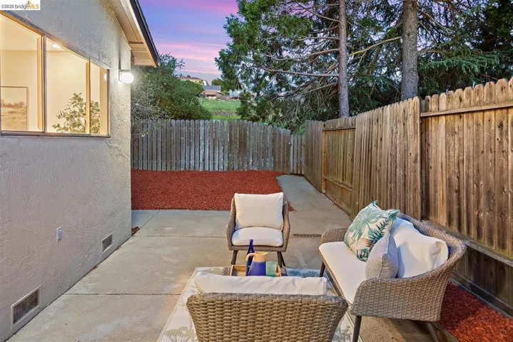 Patio terrace at dusk with a patio and a fenced backyard