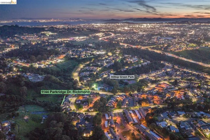 Aerial view of property and surrounding area with a mountain backdrop