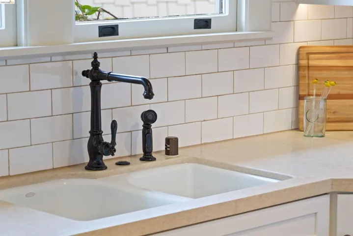 Kitchen view of decorative backsplash and white cabinets