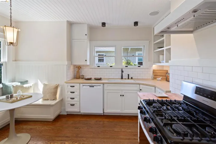 Kitchen featuring stainless steel gas range and custom hood.