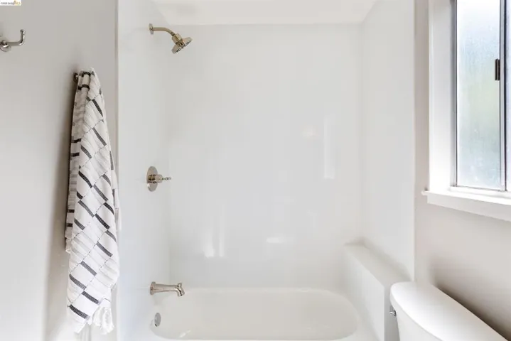 Bathroom featuring toilet and shower / tub combo with curtain