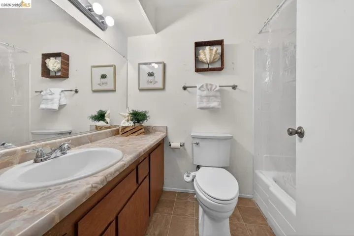 Bathroom with vanity, light tile patterned floors, and shower / bath combination with curtain