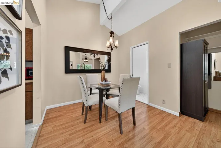 Dining space with light wood-style flooring, hanging lights, and lofted ceiling