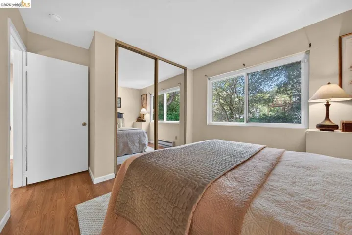 Bedroom with wood finished floors and a closet