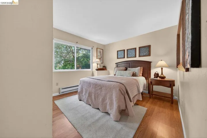 Bedroom featuring wood finished floors and a baseboard radiator