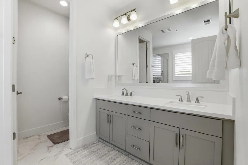 Sophisticated primary bath with dual vanities, sleek quartz surfaces,
