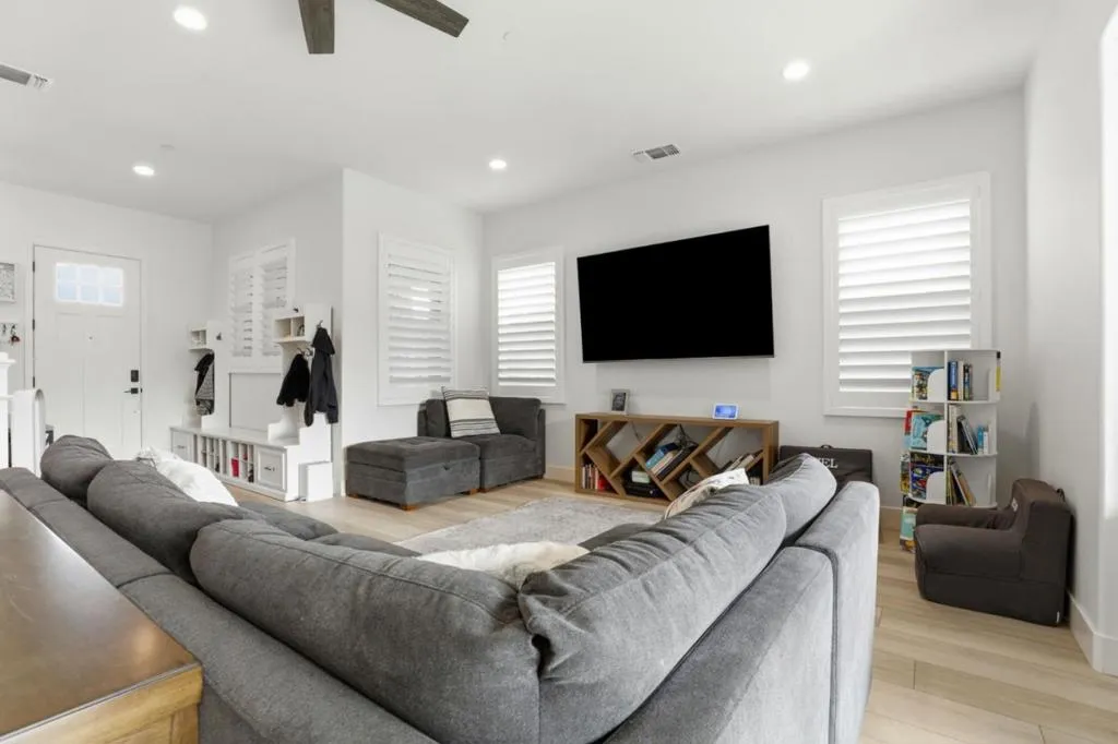 Bright, inviting living room featuring an open layout, luxury vinyl plank flooring, and shutters.