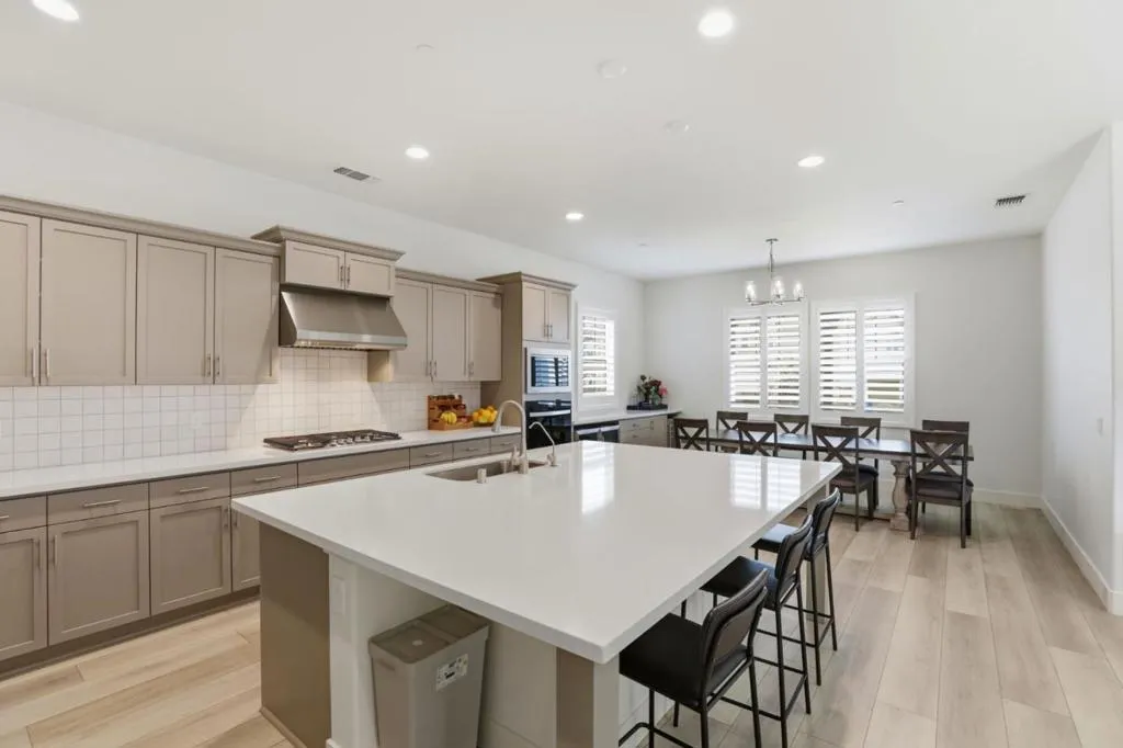 xpansive quartz island with built-in sink. Open-concept kitchen. Upgraded Cabinets.
