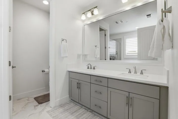 Sophisticated primary bath with dual vanities, sleek quartz surfaces,