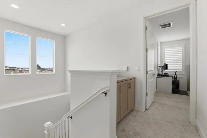 Bright, airy upper-level landing featuring abundant natural light, built-in storage.