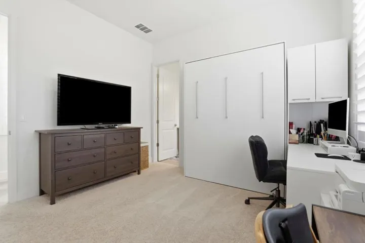 Versatile bedroom with built-in storage and space for a home office setup.