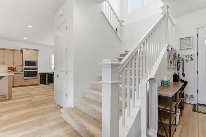 Bright entryway with staircase and open flow to the kitchen and living areas.