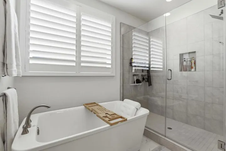 Luxurious primary bathroom showcasing a freestanding soaking tub and expansive glass-enclosed shower