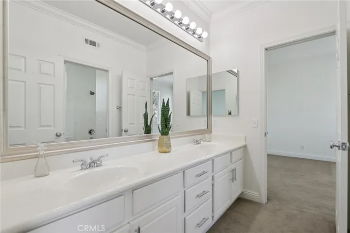 Expansive dual-sink vanity with extended counter space and direct access to the adjoining bedroom
