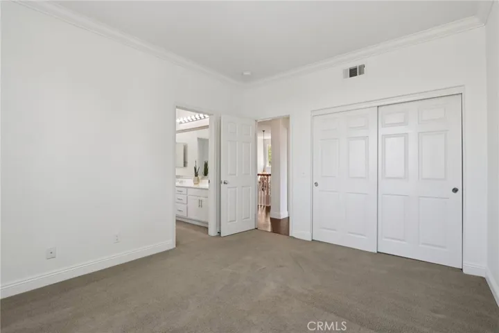 Spacious bedroom with direct access to a dual-sink bathroom and ample closet space