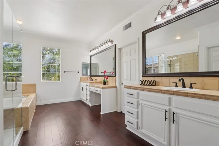 Spacious primary bathroom with dual vanities, soaking tub, and separate walk-in shower