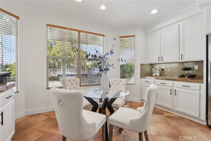 Bright breakfast nook with surrounding windows and built-in cabinetry