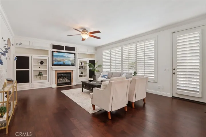 Comfortable family room with a fireplace, built-in shelving, and a bright layout with direct outdoor access