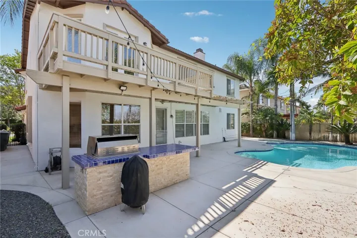 Private backyard with pool, covered patio, and built-in BBQ—ideal for outdoor entertaining