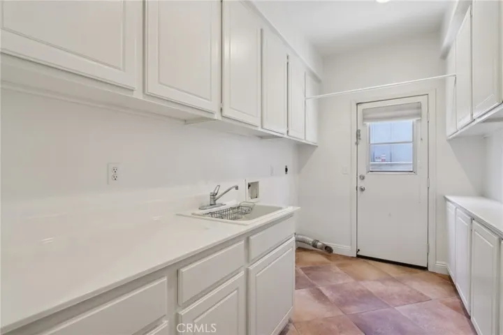 Laundry room with sink, counter space, and generous cabinetry