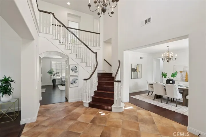 Open foyer with a sweeping staircase flowing into the formal dining area