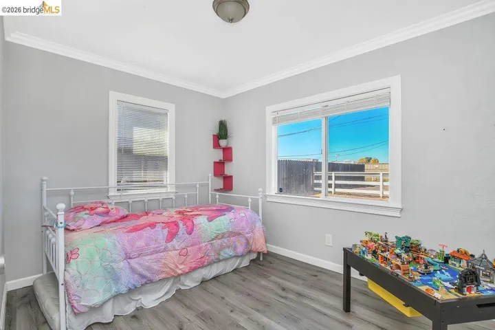 Bedroom featuring wood finished floors and ornamental molding