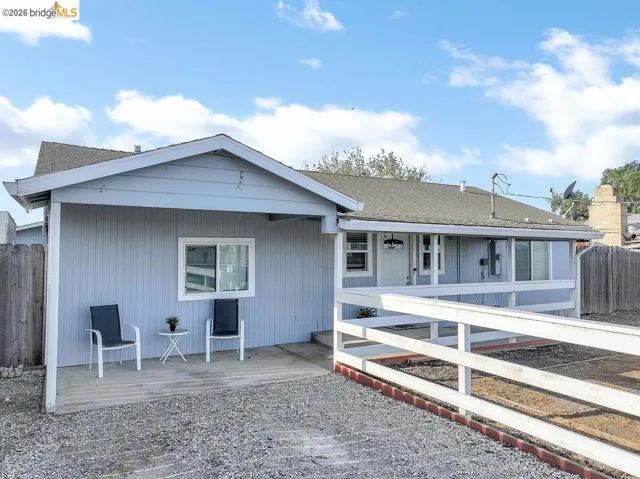 View of front of house with a wooden deck and a shingled roof