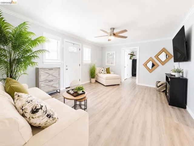 Spacious open-concept living area featuring light wood-finish flooring, recessed lighting, and a ceiling fan