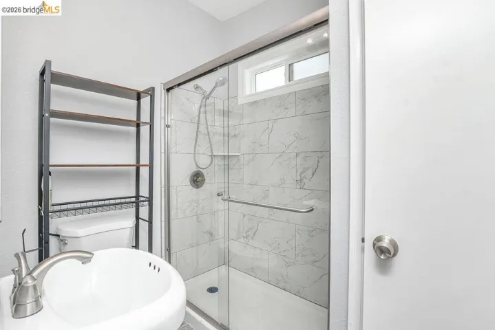 Bathroom featuring a stall shower and a sink