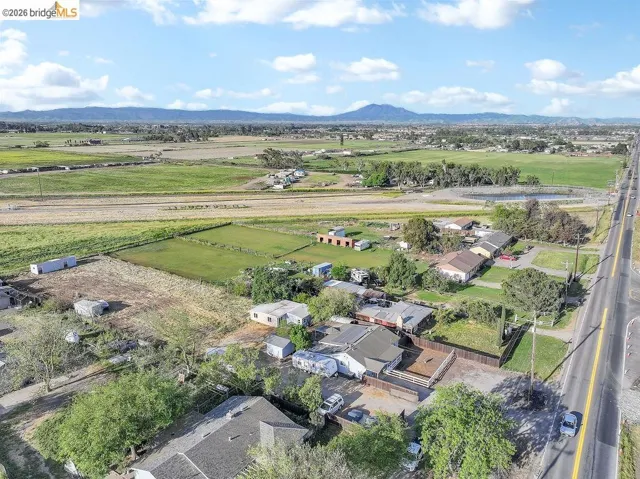 Aerial view of sparsely populated area with a mountain backdrop and nearby suburban area