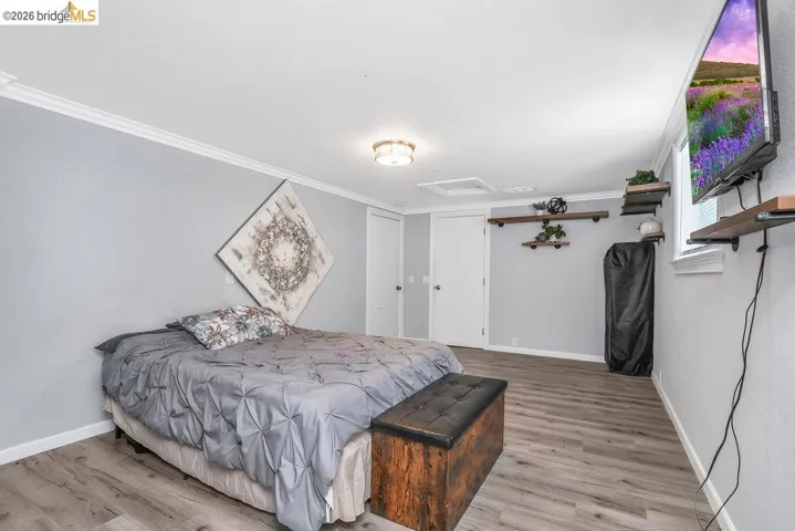 Bedroom featuring light wood-style flooring and crown molding