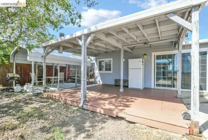 Back of house featuring stucco siding and a wooden deck