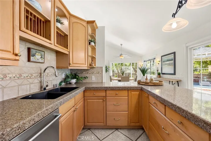 Incredible storage throughout with two lazy Susan's, deep drawers for pots and pans, and plenty of cabinetry, all complemented by framed double-pane sliding glass doors overlooking the back and side yard.