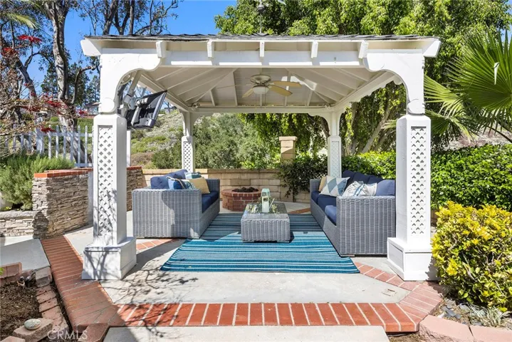 Inviting outdoor gazebo with ceiling fan and lighting, complete with a cozy fire pit and gas line for your BBQ—an ideal space to relax and entertain family and friends.