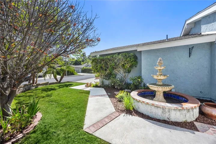Peaceful front setting with a soothing fountain, winding walkway, and a mature flowering plum tree that brings beautiful seasonal color to the yard.