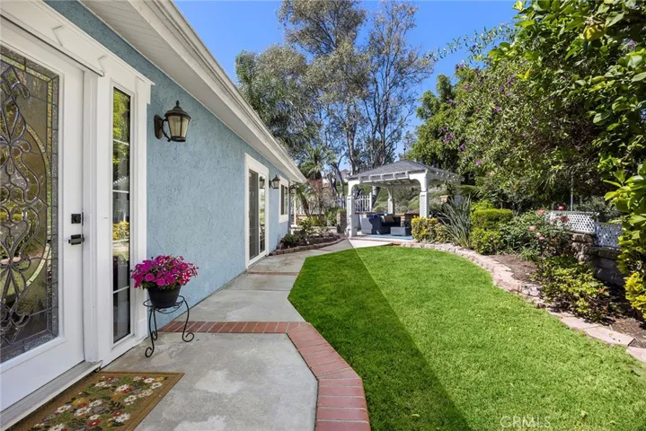 Private backyard with a green, well-kept lawn and garden-lined paths that lead to an extra large gazebo—an easy spot to hang out with friends and family, watch the game, fire up the BBQ, or just relax. And no neighbors behind you.