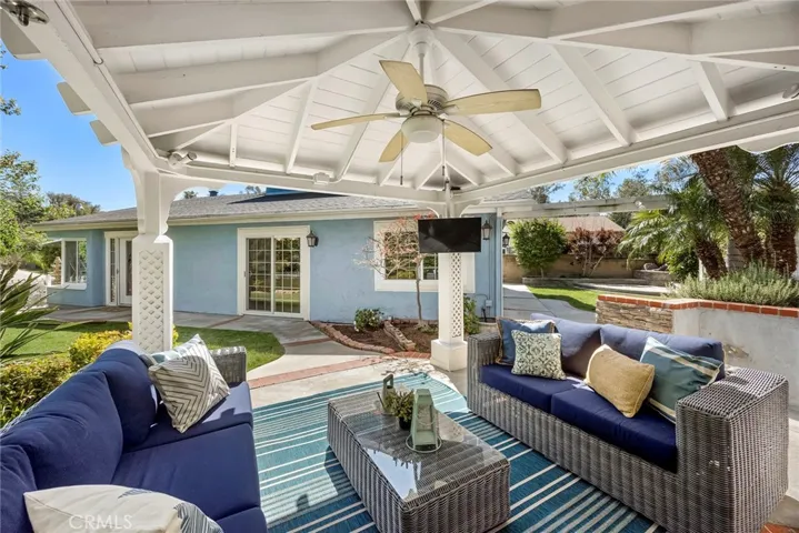 Relax under the covered gazebo featuring a ceiling fan, lighting, and mounted TV, all overlooking the beautifully landscaped backyard—perfect for year-round entertaining.